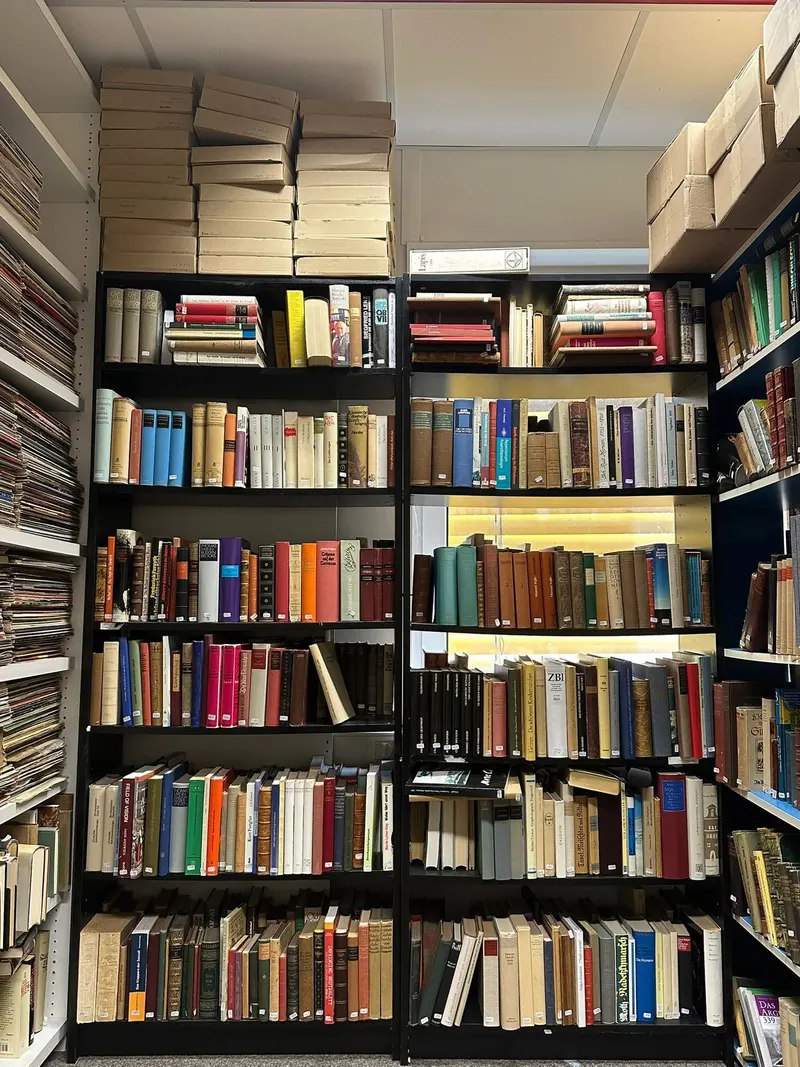 Blick in unser Lager: sortierte Bücher in hohen Regalen